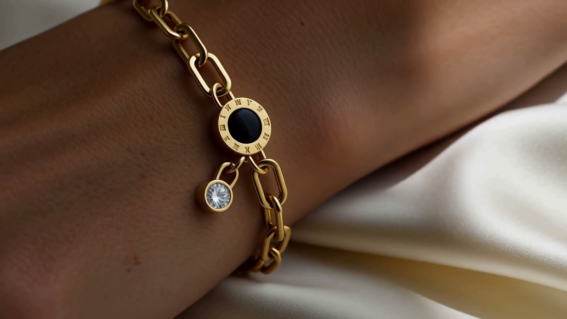 Lenkearmbånd med romertall og zirkonia i 18K gullbelagt stål på en håndledd